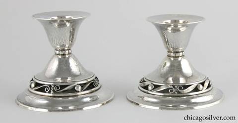 Kalo candlesticks, low, pair (2) in the Norse Line with broad circular base with open work band featuring a repeated bead and scroll design supporting a small, flared cup.  Hand engraved on the underside "BH DCL / September 24, 1938"  Nicely hammered.  Part of console set.  3-3/8" H and 4" W.  
One marked:  STERLING HAND WROUGHT KALO SILVERSMITHS NS42
Other marked:  STERLING KALO NS42

