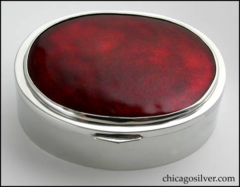 Rebecca Cauman box, pewter, oval, with hinged lid.  Lid is covered with deep rich red bezel-set enamel plaque.  