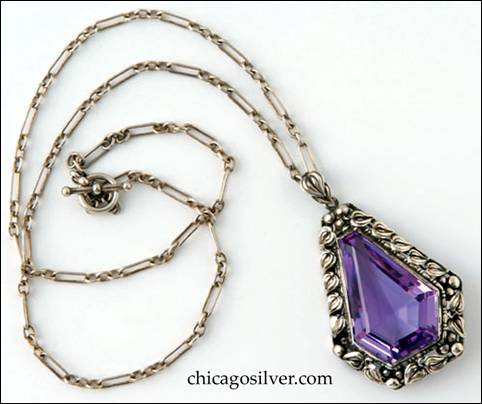 Pendant, 2" H, on chain 19" L.  Handwrought in sterling silver by James Scott of the Elverhj community, the pendant features elegantly fashioned leaves and beadwork forming a border around a central teardrop-shaped faceted amethyst.  