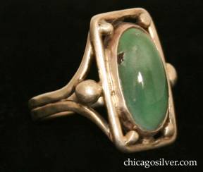 Forest Craft Guild ring, with large rectangular silver frame centering an oval mottled green bezel-set cabochon turquoise stone, four silver beads at the inside corners, and two larger beads outside the frame at the sides.  Split shank.