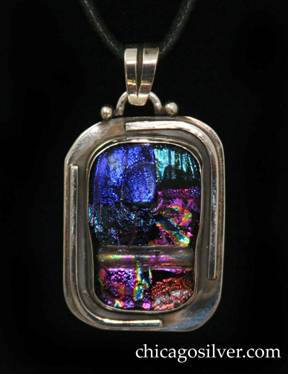 Laurence Foss pendant on cord, rectangular with rounded corners, wide silver frame centering rectangular bezel-set thick handmade iridescent glass stone with rounded corners.  Applied curving wire ornament around top right and lower left part of frame.  Semicircular loop applied to top with bead at each end, and chased moveable bale.  On black leather cord with key-like fastener.  