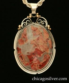 Foss pendant on chain.  Large oval bezel-set transparent cabochon milky white stone with dark and light red inclusions inside notched bezel and frame.  Spiraling silver wirework and gold beads at the top supporting the bale.  Heavy silver chain.
