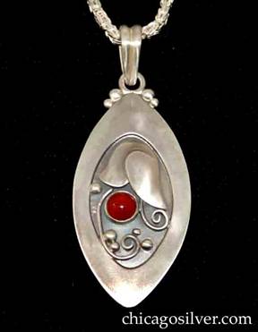Foss pendant on chain, oval, with pointed ends and wide raised edge, oxidized background, applied stylized tulip with silver beads and curving wirework ornament, and round red bezel-set carnelian stone.  