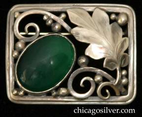 Laurence Foss brooch, rectangular, on silver wire frame with rounded corners, large chased and serrated oak leaf at the upper right corner and a perpendicular angled bezel-set cabochon oval deep green onyx stone at the lower left corner, with applied beads and thick wirework decoration.  Very much in the style of Edward Oakes.  