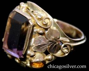 Laurence Foss ring, 14K gold, centering large purple/yellow ametrine rectangular faceted bezel-set stone, with a small round faceted citrine bezel-set stone on one side and a small round faceted amethyst bezel-set stone on the other, surrounded by lovely bead and wirework ornament and an applied chased leaf on either side.  Very much in the style of Edward Oakes. 