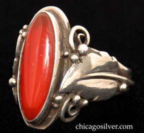 Laurence Foss ring, silver, with large slender oval vertical bezel-set cabochon carnelian stone in oxidized frame surrounded by an applied serrated leaf with a prominent central vein and beads and wirework decoration on each side.  A wire runs around the back of the ring connecting the bottoms of each leaf stem