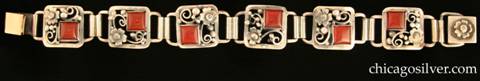 Laurence Foss bracelet, with carnelians.  Six square slightly convex open links, each with a flower blossom, silver beads, wirework scrolls, and a square bezel-set deep red cabochon carnelian stone in one corner.  Additional applied flower blossom on a separate clasp.  While all Foss bracelets are handsome, this one is also especially lovely, and is very much like the work of Oakes.  