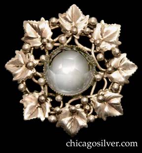 Mary Gage pin, round, composed of a circle of eight chased leaves surrounding a central cabochon clear round crystal or quartz stone