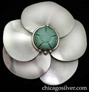 Lillian Pines brooch / pin, large, round, in the shape of a stylized flower blossom, composed of smooth overlapping petals separated by small silver beads, and centering a carved bezel-set turquoise or jade blossom inside a silver ring ornamented with silver beads.