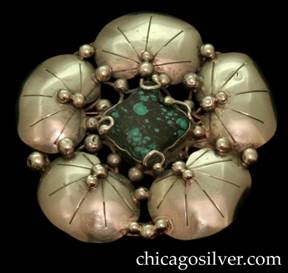 Mary Gage brooch / pin, flower form, round, composed of five chased lily pads centering a square bezel-set turquoise stone with extensive black matrix, and numerous applied silver beads.  Stone is also held in place by four curving silver wire tendrils that each end in a silver bead.