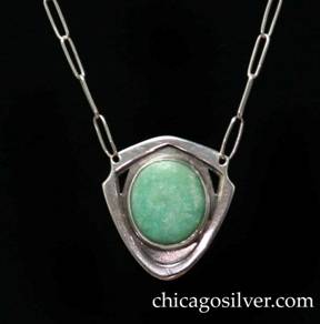 Kalo necklace / pendant, on paperclip chain, with green stone.  Shield-shaped frame with wide edge and recessed area between the frame and bezel.  Two slight notches at the upper left and right corners beside small triangular cutouts, centering a green oval bezel-set stone.  Chain attaches to two holes near the notches.