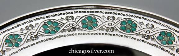 Closeup of Mary Catherine Knight bowl, low, round, enameled, on flat foot, with chased decoration of intertwined vines and teal enameled flowers with cream-colored centers around the edge, and a smaller ring of these around the bottom.  Applied thick wire to rim.  Heavy and in excellent shape.  Enamel is in excellent condition.