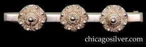 Lebolt pin, made of thick rectangular bar with beveled edges and three cone-shaped ornaments on top made of small round constructions of coiled wire centering small metal beads