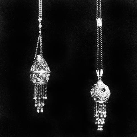 Two pendants, one in form of lantern tipped with baroque pearl suspended  on simple chain; the other elaborately wrought foliated design on gold base, suspended on black cord, by Edward E. Oakes