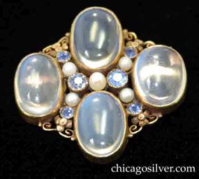 Brooch, by Edward Oakes, hand wrought in 14K green gold with four blue moonstones with six Montana sapphires and five seed pearls.  Fine, delicate and highly detailed foliate and scroll work between the gem stones.  Excellent work.