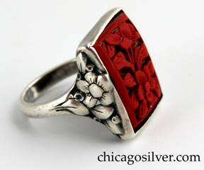 Ring, by Edward Oakes, silver, with bezel-set rectangular cinnabar stone deeply carved with floral motif inside frame.  Sides have similar flower and leaf design.  Owned by a Wakefield, Massachusetts neighbor of Oakes who had it custom made by Oakes.