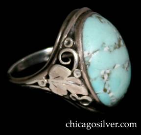 Ring, by Gilbert Oakes, handwrought in sterling silver with central, oval, light blue turquoise cabochon.  The shank has applied silver foliate and leaf ornament with beads and scrolls.  Shank is worn.