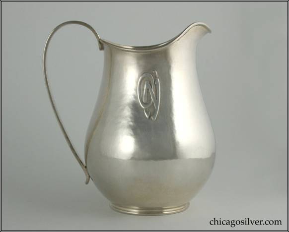 Kalo pitcher, with wide bottom tapering to thin neck and then flaring out slightly, with arching spout, looping heavy strap handle, applied O'N monogram on side.  On small ring foot, with applied wire to rim.  Lovely hammering and shape.  7" H and 6-1/4" W.  STERLING / HAND WROUGHT / AT / THE KALO SHOPS / CHICAGO / AND / NEW YORK / 9440