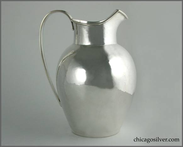 Kalo pitcher, water, bulbous ovoid body with tall collar above, applied wire on rim, looping hollow handle.  Nice hammering.  NOTE:  This has an unusual mark -- there's no "STERLING" present but it is clearly silver.  8-1/2" H and 6-1/2" W.  HAND WROUGHT / AT / THE KALO SHOPS / CHICAGO / AND / NEW YORK / 872 / G