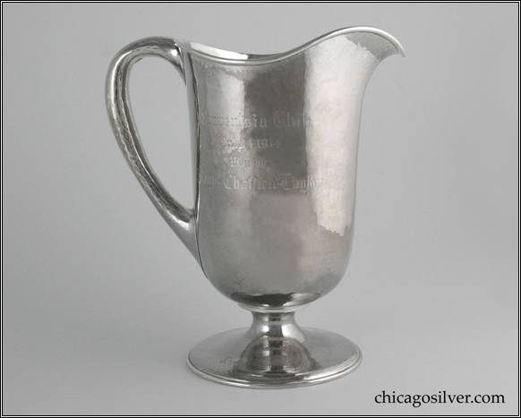 Kalo pitcher, trophy, with cylindrical body necking in at bottom to wide round foot, and flaring out at top to arching spout.  Looping hollow handle, applied wire to rim.  Nicely hammered surfaces.  Engraved on side is "Onwentsia Club / Won by / Wayne Chatfield-Taylor".  Engraved on top of foot is "Choice Score Cup".  Engraved on underside of foot is "Presented by / W. A. Alexander / and / Thomas Taylor Jr." 8" H and 7-1/8" W.  STERLING / HAND BEATEN / AT / KALO SHOPS / PARK RIDGE / ILLS. / 9283
