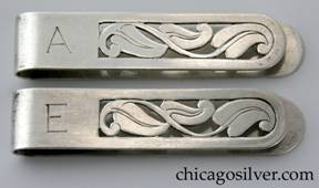 Potter Mellen napkin clips, pair (2), each with one open side, curved ends, and chased and pierced curving leaves in the center.  Engraved "A" mono at the closed end of one and engraved "E" at the closed end of the other.