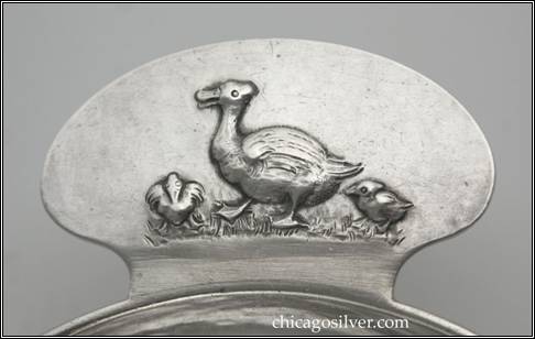 Kalo porringer, flaring bowl with applied wire on rim and tab-like handle which has a chased and repousse design featuring a mother duck with two smaller ducklings.  Hammered surface.  Engraved DOROTHY on side.  Detail shown.