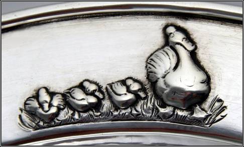Kalo plate, child's, round, with raised border, repousse design of mother duck with ducklings, engraved "Jayne Austin", applied wire on rim -- detail
