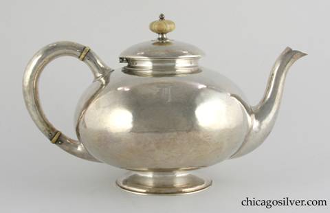 Kalo tea pot, raised globe form on low pedestal foot, arching spout and looping hollow handle, broad overlapping domed lid with turned ivory finial, ivory insulators on handle, hammered surface.  Engraved D monogram on side.  6-1/2" H and 10-1/2" W.  marked:  STERLING / HAND WROUGHT / AT / THE KALO SHOP