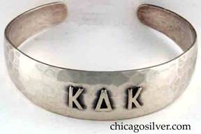 Art Metal Studios bracelet, with open back and tapering rounded ends, applied "K Δ K" mono, nice hammering.