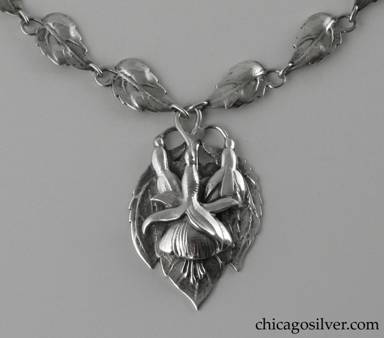Peer Smed necklace, silver, composed of 16 leaf-form links each with a stem that curves around and forms a loop, centering a large pointed oval plaque with chased fuchsia blossoms and leaves.  Plaque is heavy and dimensional.  Long thin interesting clasp with applied curving decoration.